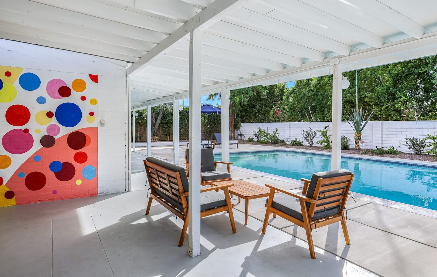A shaded dining table and chairs on The Kasbah's private poolside patio