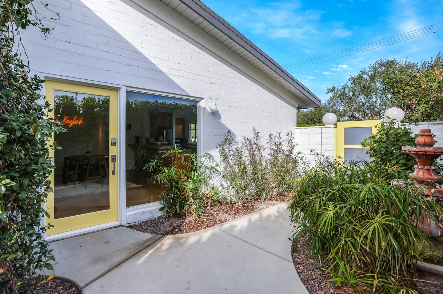 The Kasbah's yellow courtyard door, fountain and garden in Movie Colony East
